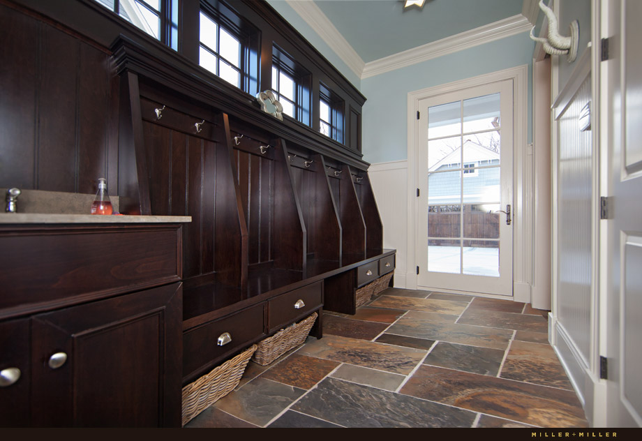 mud room custom built in hooks drawers dark wood slate floor blue walls